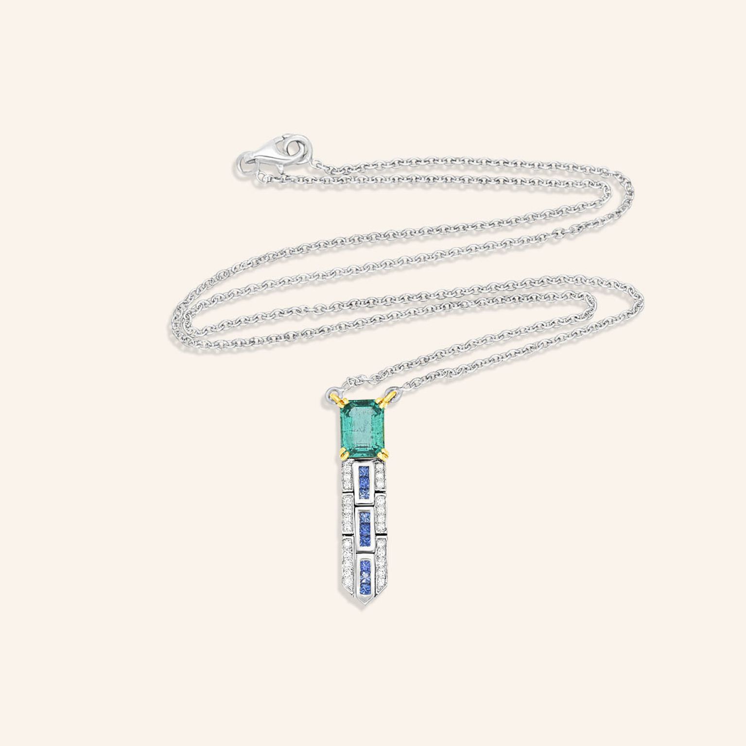 Collier or gris, émeraude et saphirs